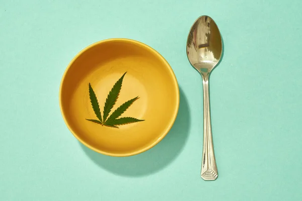 Fresh Green Marijuana Leaf Yellow Bowl Spoon Isolated Turquoise Background — Stockfoto