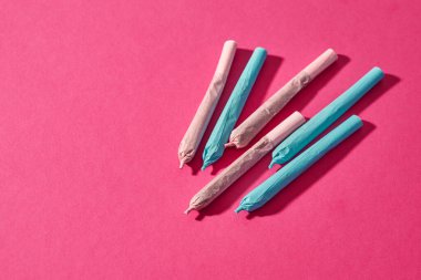 Pembe arka planda izole edilmiş esrar sarma eklemleri. Yasallaştırılmış hafif uyuşturucu ve bağımlılık. Bitkisel ilaçlar ve ağrı kesici tedavisi. Doğal organik kenevir. Uyuşturucu satıcılığı. Boşluğu kopyala