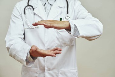 Erkek doktorun el ele tutuşurken görüntüsü. Steteskoplu beyaz önlüklü bir adam. Tıp ve sağlık hizmetleri kavramı. Stüdyo çekimi. Beyaz arkaplanda izole