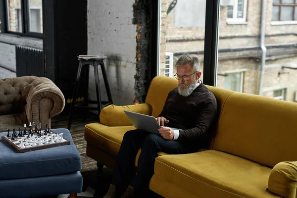 Grey Hair Caucasian Man Using Watching Laptop Sofa Spacious Flat — Stockfoto