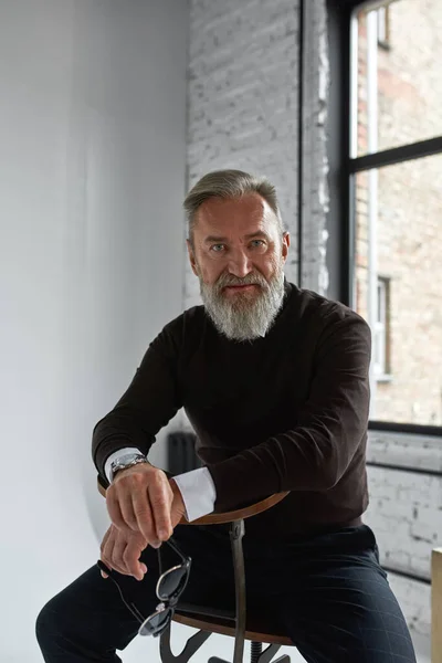 Elderly Confident Caucasian Man Sitting Chair Looking Camera Spacious Apartment — Stockfoto