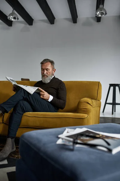 Senior Concentrated Caucasian Man Reading Newspaper Sofa Spacious Apartment Stylish — Photo
