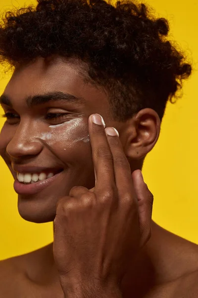 Cropped Image Smiling Black Guy Smearing Cosmetic Cream His Face — Φωτογραφία Αρχείου