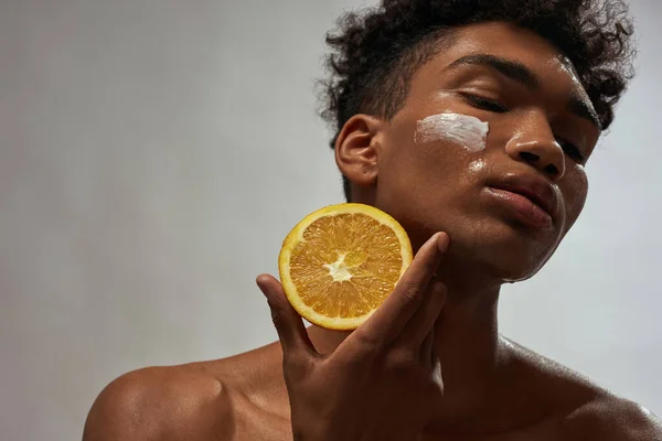 Partial Beautiful Black Guy Holding Orange Cosmetic Cream His Face — Stock Fotó