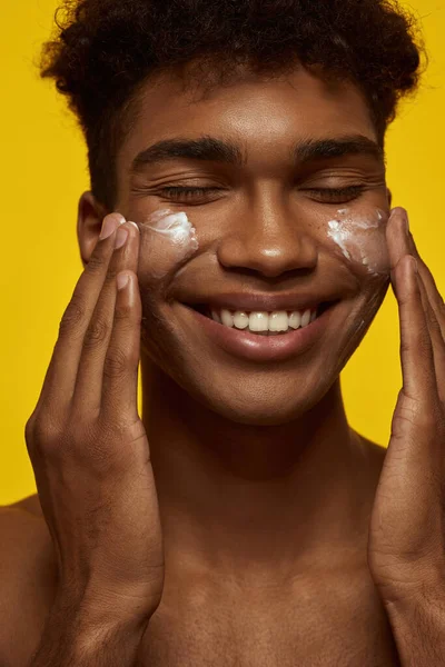 Cropped Smiling Black Guy Smearing Cosmetic Cream His Clean Face — Stok Foto