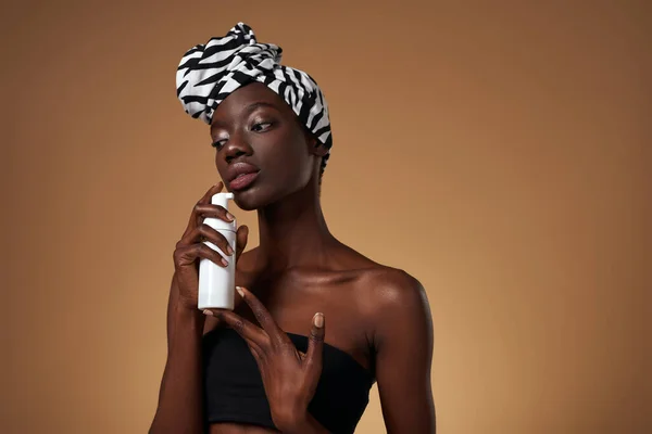 Kozmetik Kremli Bir Şişe Tutan Düşünceli Siyah Kız Geleneksel Afrika — Stok fotoğraf