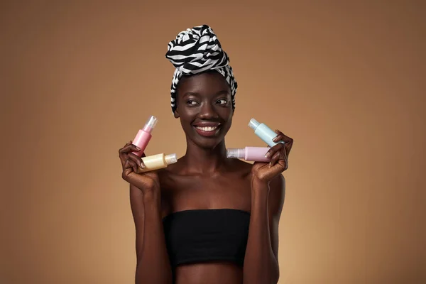 Smiling Black Girl Holding Four Colorful Nail Polishes Looking Away — 스톡 사진