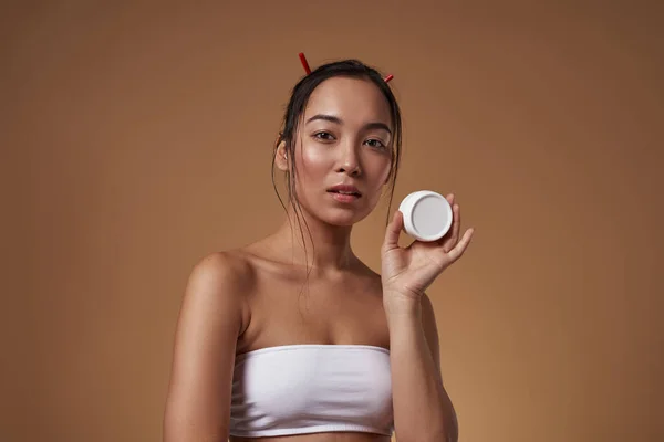 Serious Elegant Asian Girl Holding Container Cosmetic Cream Beautiful Young — Φωτογραφία Αρχείου