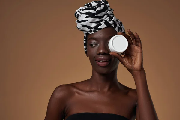 Black Girl Covering Eye Container Cosmetic Cream Looking Away Young — Stockfoto