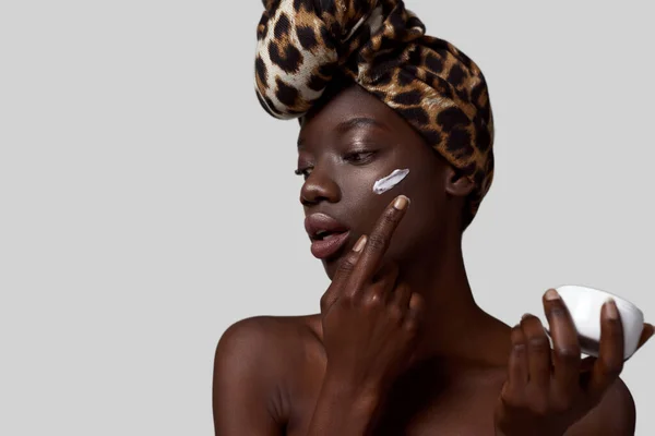 Fashionable Black Girl Smearing Cosmetic Cream Container Her Face Pretty — Zdjęcie stockowe
