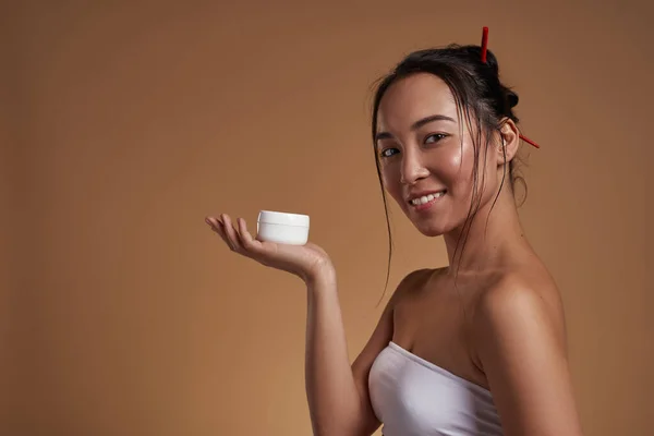 Side View Smiling Asian Girl Holding Container Cosmetic Cream Hand — Stockfoto