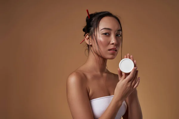 Stylish Asian Girl Holding Container Cosmetic Cream Looking Camera Attractive — Stockfoto