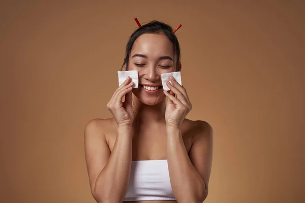 Smiling Fashionable Asian Girl Closed Eyes Wiping Her Face Cotton — Stockfoto