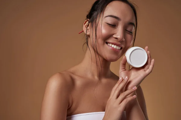 Smiling Elegant Asian Girl Closed Eyes Holding Container Cosmetic Cream — Stockfoto