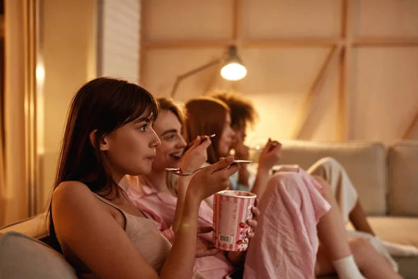 Young Multiracial Girlfriends Eating Ice Cream Watching Movie Sofa Girlish — Foto de Stock