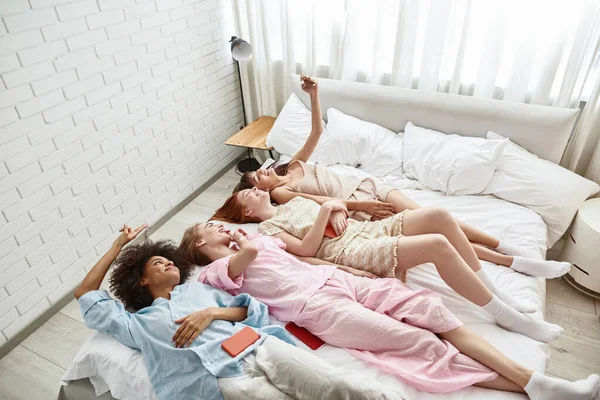 Young Pleased Multiethnic Girlfriends Lying Bed Taking Selfie Smartphone Girlish — Stok Foto