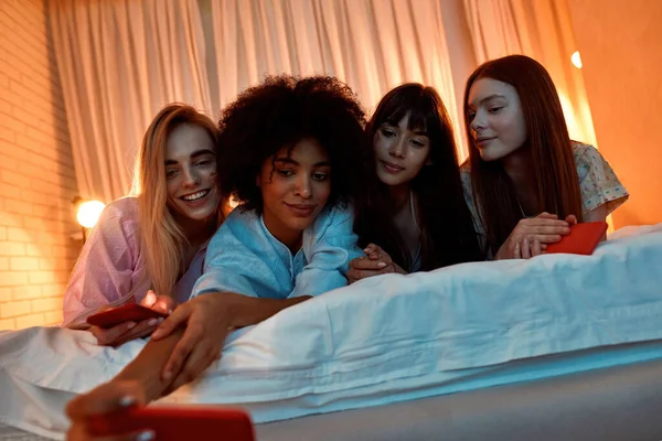 Young Multiethnic Girlfriends Taking Selfie Smartphone Bed Girlish Sleepover Night —  Fotos de Stock