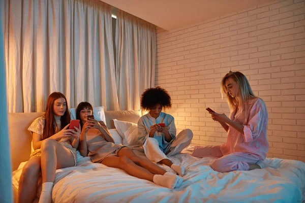 Young Focused Multiracial Girlfriends Use Smartphones Bed Girlish Sleepover Black —  Fotos de Stock