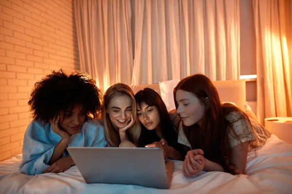 Young Multiracial Girlfriends Watching Laptop While Lying Bed Girlish Sleepover —  Fotos de Stock