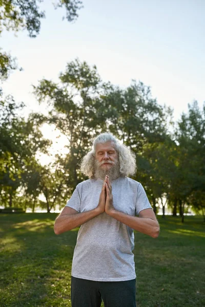 Focused European Grey Hair Man Closed Eyes Practicing Yoga Meditating — Zdjęcie stockowe