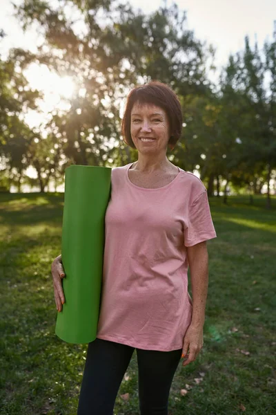 Smiling Middle Aged Caucasian Woman Fitness Mat Green Lawn Park — Zdjęcie stockowe