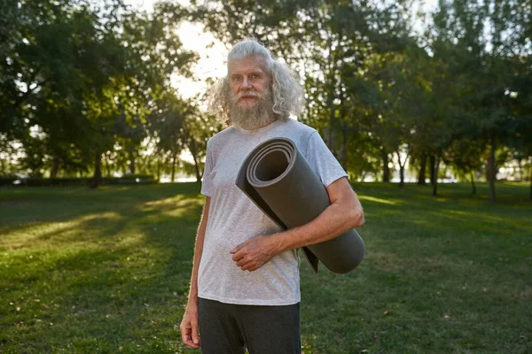 Serious Caucasian Grey Hair Man Fitness Mat Green Meadow Park — Zdjęcie stockowe