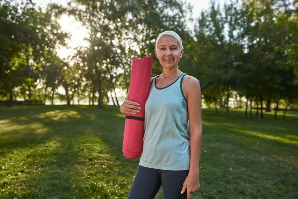 Smiling Caucasian Grey Hair Woman Fitness Mat Green Lawn Park — Zdjęcie stockowe