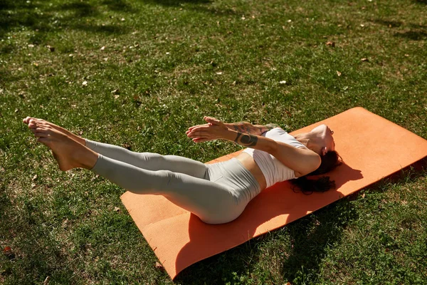 Young Caucasian Sportswoman Practicing Yoga Extended Leg Pose Sunny Park — Zdjęcie stockowe
