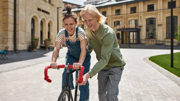 Guy Helping His Girlfriend Riding Bicycle City Modern Urban Healthy — Stock Photo, Image
