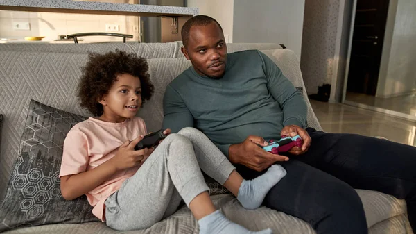 Niño Negro Padre Jugando Videojuegos Con Joysticks Sofá Casa Espaciosa —  Fotos de Stock
