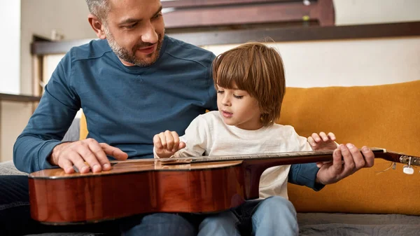 Baba Evdeki Kanepede Akustik Gitar Çalan Küçük Çocuğa Ders Veriyor — Stok fotoğraf