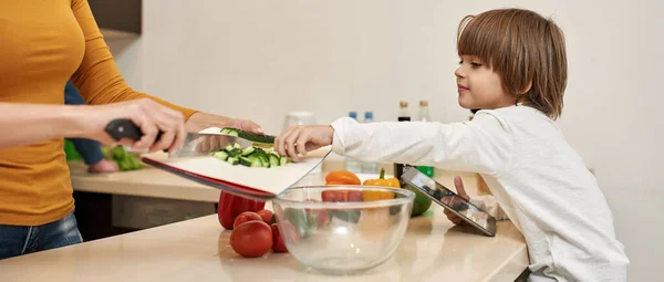 Dijital Tabletli Beyaz Çocuk Salatalık Dilimleme Tahtasından Mutfağında Salata Için — Stok fotoğraf