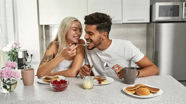 Caucasian Girl Feeding Her Middle Eastern Boyfriend Pancake Having Breakfast — Stock Photo, Image