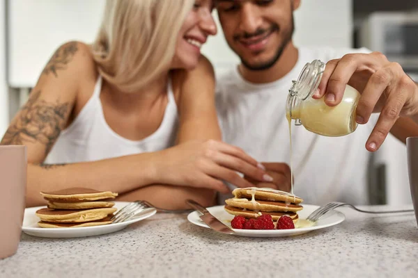 Focus Middle Eastern Man Pouring Condensed Milk Pancakes Plate Raspberry — Stock Photo, Image