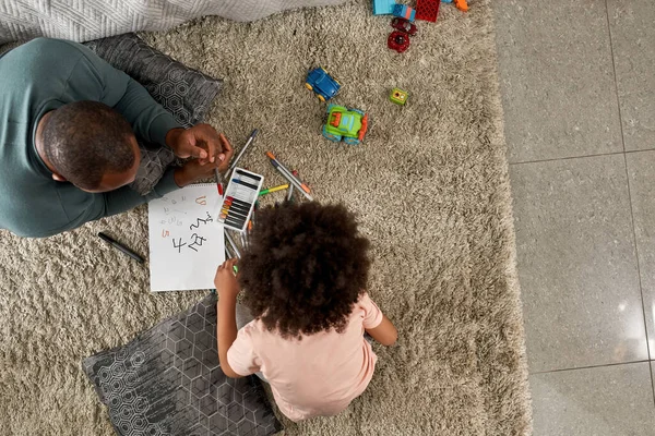 父亲和儿子在家里的地毯上用毛毡笔画数字的头像 黑人家庭在一起的时间 父亲和养育子女 家庭休闲 业余爱好和娱乐 — 图库照片