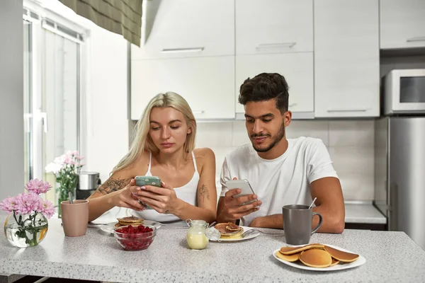 Giovane Concentrato Coppia Multietnica Utilizzando Guardando Gli Smartphone Durante Colazione — Foto Stock