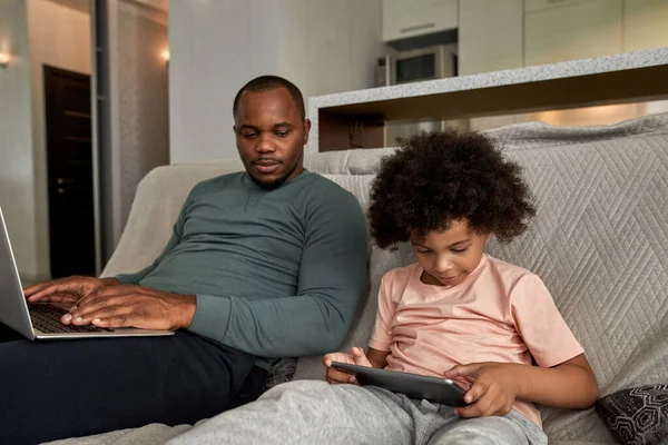 Pai Adulto Com Laptop Olhando Para Seu Filho Usando Tablet — Fotografia de Stock