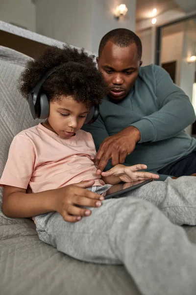 Pai Ajudando Seu Filho Usando Tablet Digital Sofá Casa Estilo — Fotografia de Stock
