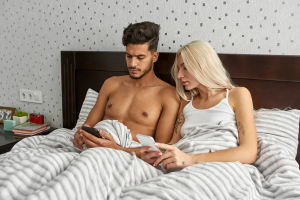 Cuplu Multietnic Concentrat Tânăr Folosind Smartphone Pat Acasă Fata Europeană — Fotografie, imagine de stoc