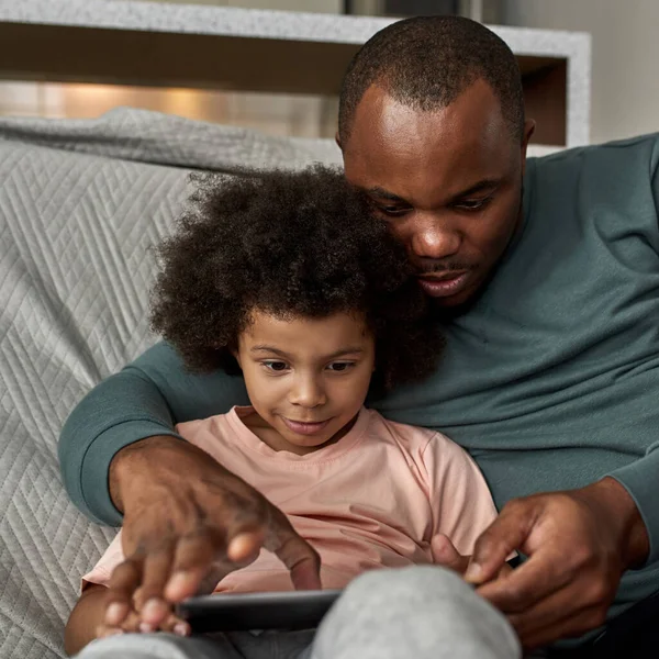 Apa Kisfiú Használja Böngészni Digitális Tabletta Kanapén Otthon Fiatal Fekete — Stock Fotó