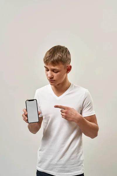 Kaukasischer Teenager Zeigt Und Schaut Aufs Smartphone Blonder Typ Der — Stockfoto