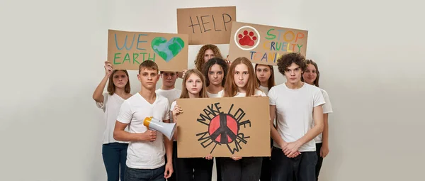 一群欧洲少年拿着硬纸板和平标语牌举行民主集会 做爱而不是战争 我们地球 救命啊别再虐待动物了被隔离在工作室的白色背景中 复制空间 — 图库照片