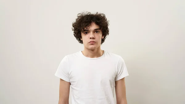 Portret Poważnego Białego Nastolatka Patrzącego Kamerę Kędzierzawy Facet Zoomerem Koszulce — Zdjęcie stockowe