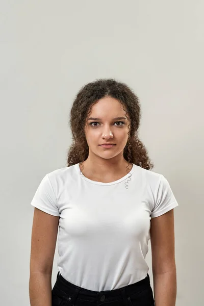 코카서스 소녀가 카메라를 세대의 티셔츠와 청바지를 젊은이들의 배경에 고립되어 있습니다 — 스톡 사진