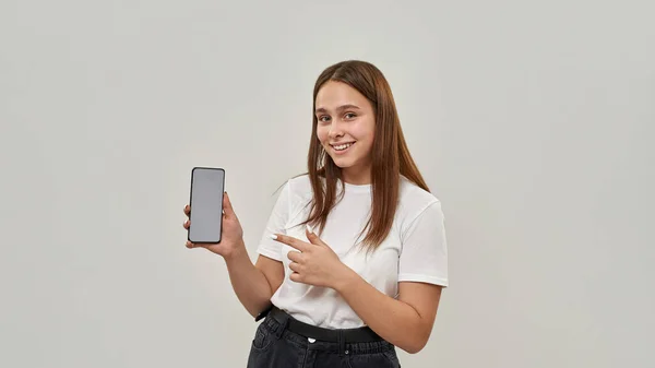 Leende Kaukasisk Kvinnlig Tonåring Visar Smartphone Och Tittar Kameran Flicka — Stockfoto