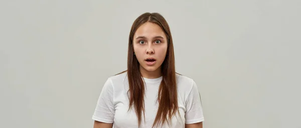 震惊的高加索女性青少年 张大嘴看着相机 一个穿T恤的男同性恋女孩 现代年轻人生活方式的概念 被隔离在工作室的白色背景中 复制空间 — 图库照片