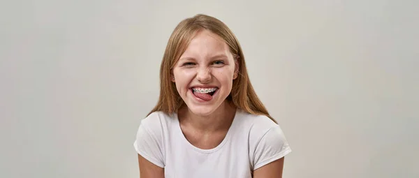 一个笑容可亲的少女伸出舌头 看着镜头的画像 卵母细胞发育为卵母细胞 现代年轻人的生活方式 白色背景 工作室拍摄 复制空间 — 图库照片