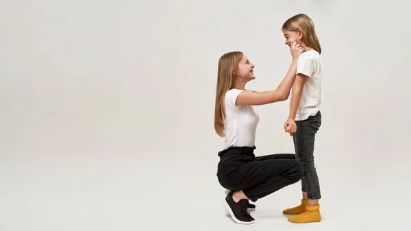Side View Teenage Girl Tugging Cheeks Little Sister Joking Caucasian — Stock Photo, Image