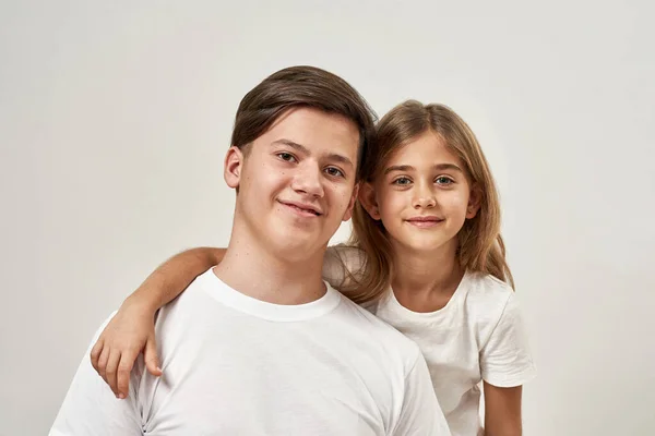 Dziewczynka Przytula Nastolatka Oni Patrzą Kamerę Uśmiechnięty Europejski Brat Siostra — Zdjęcie stockowe