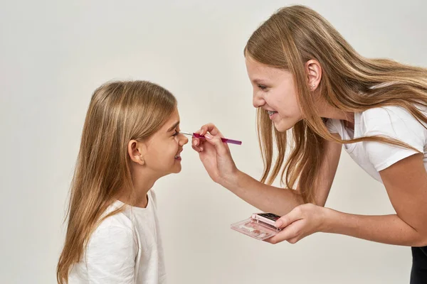 Teilseite Eines Teenagermädchens Das Mit Kosmetikpinsel Glitzerlider Der Kleinen Schwester — Stockfoto